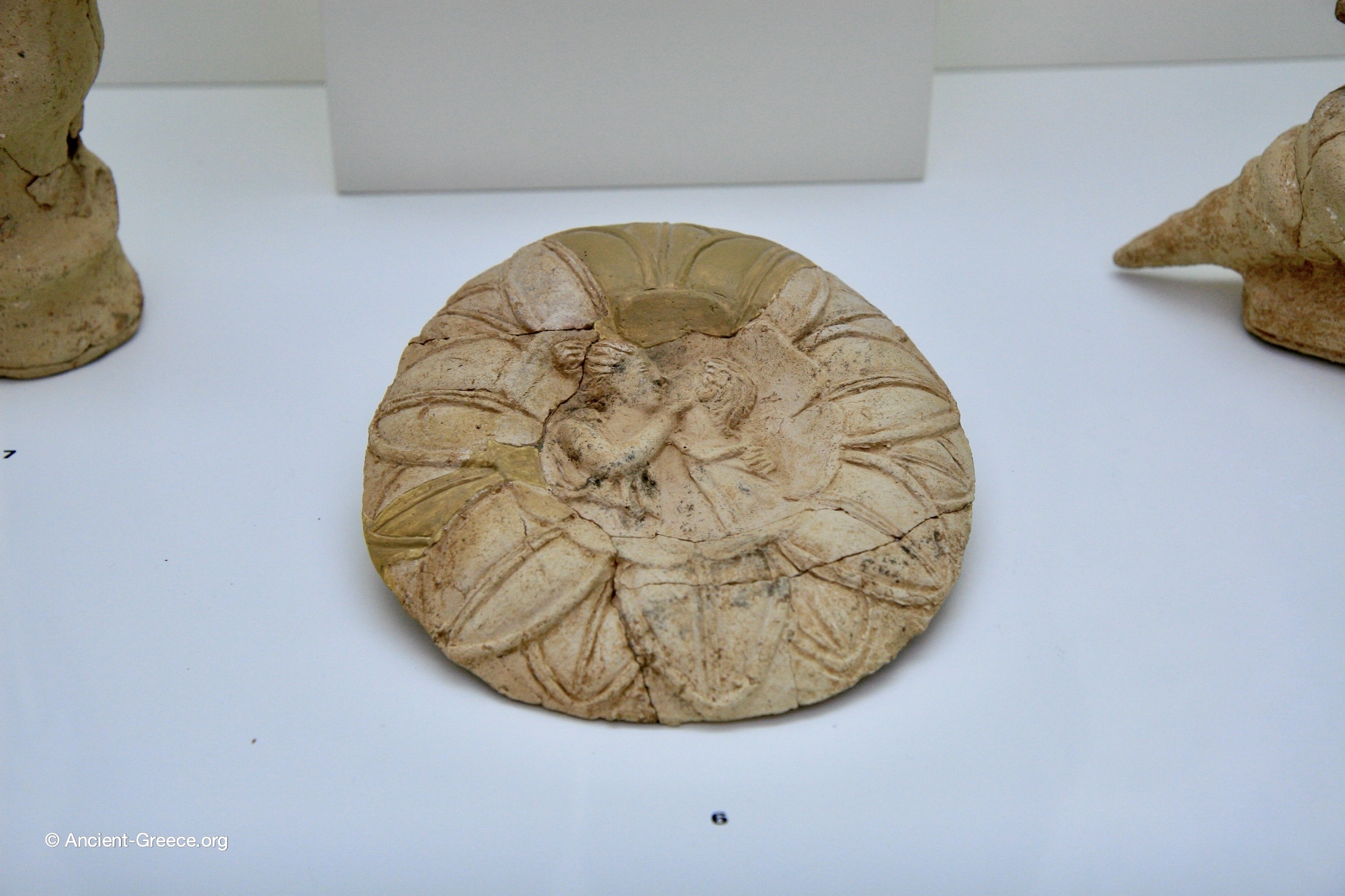 Molded Terracotta Disc with shallow relief of couple in kissing in embrace