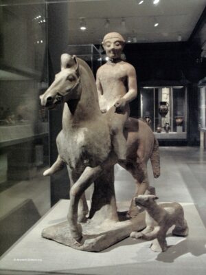 Statuette of Young hunter on horseback and running dog.