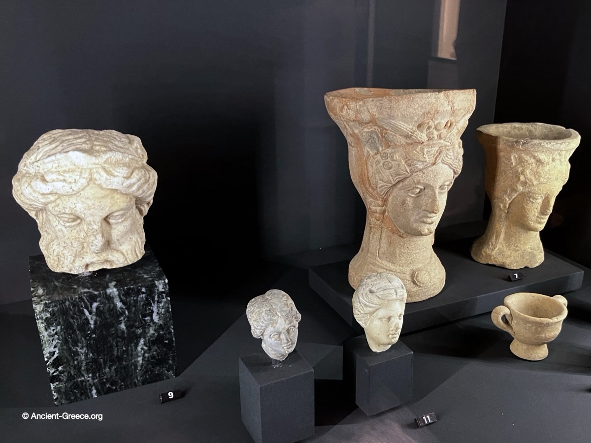 Terracotta incense burners and small marble heads.