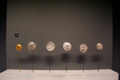 Six Ancient Greek coins on museum exhibit