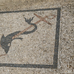 Mosaic detail depicting a dolphin wrapped around an anchor.
