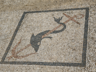 Mosaic detail depicting a dolphin wrapped around an anchor.