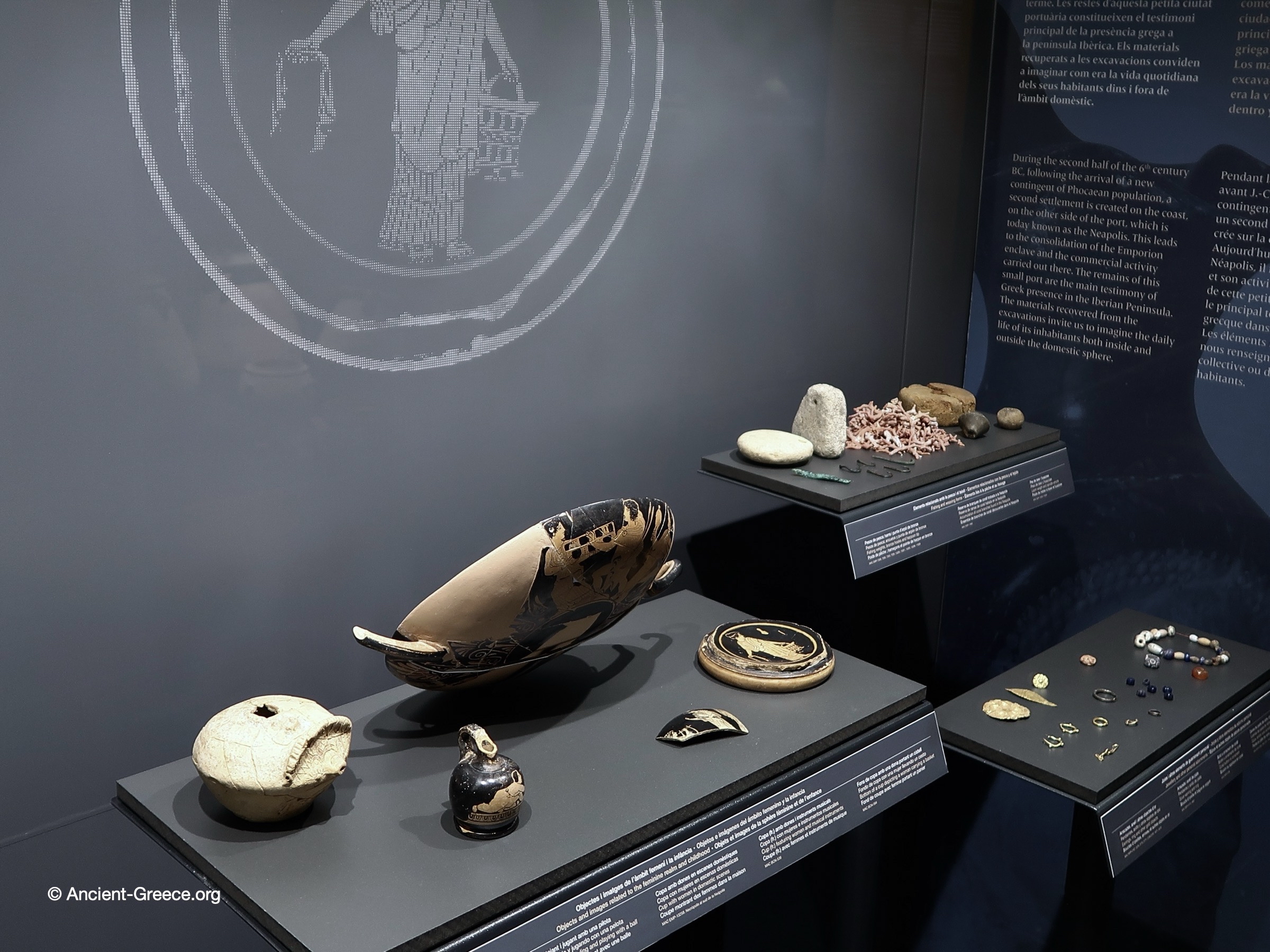 Museum exhibit of ceramics vessels with domestic scenes.