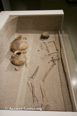 Adult burial museum reconstruction with skeleton and pottery