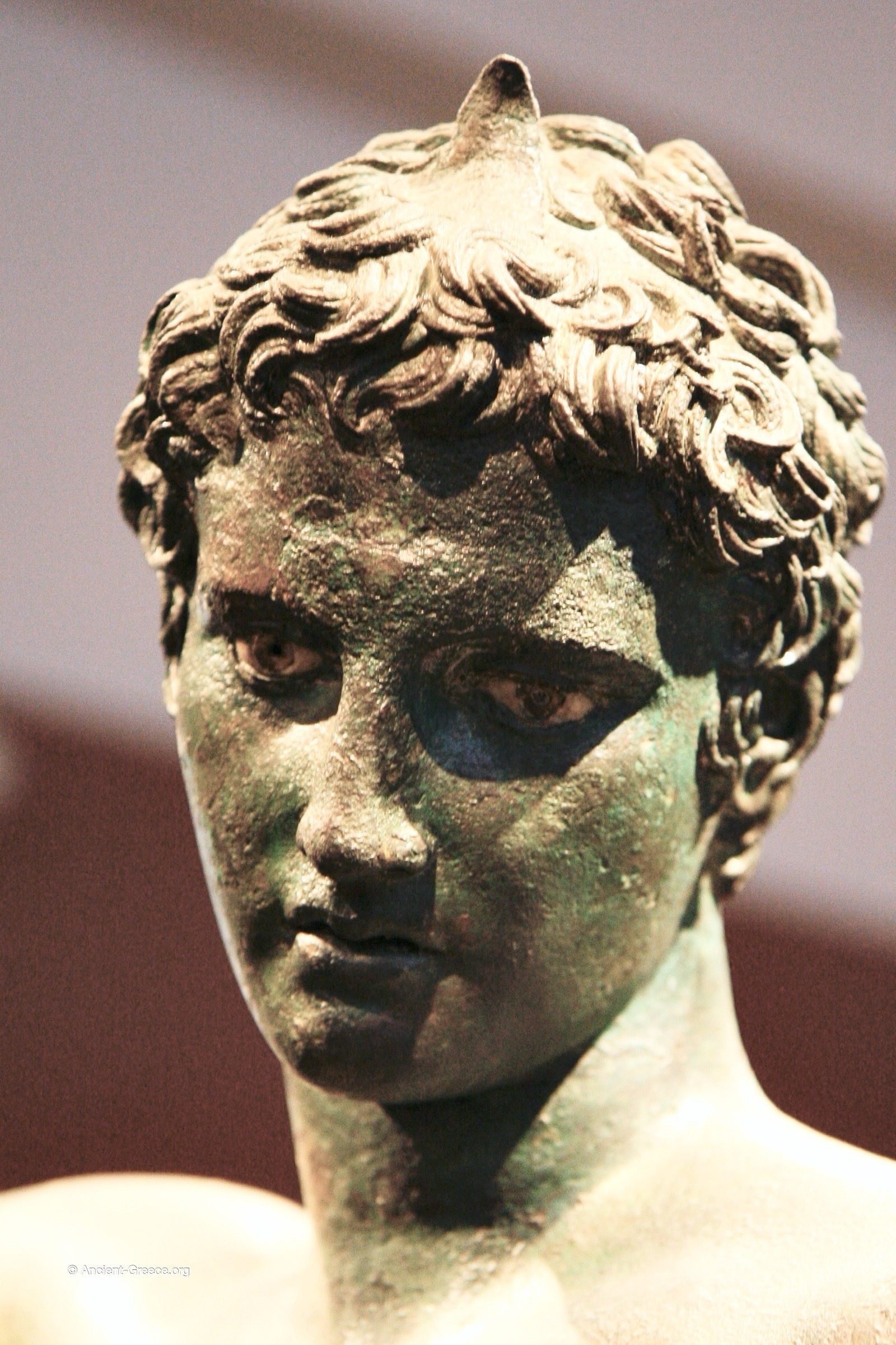 Ancient Greek art on exhibit in the National Archaeological Museum in Athens, Greece. Bronze statue of a youth studying an object. Marathon Youth. Detail of face with inlaid eyes.