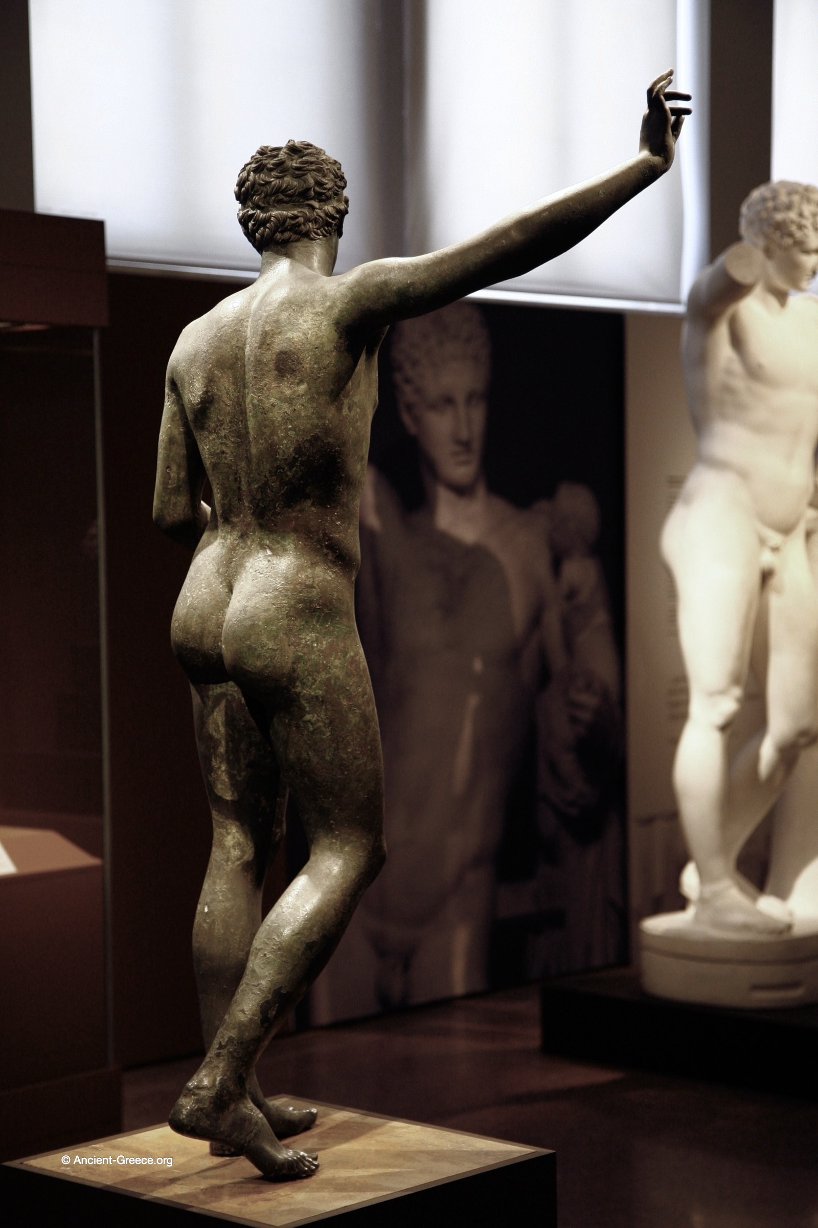 Ancient Greek art on exhibit in the National Archaeological Museum in Athens, Greece. Bronze statue of a youth studying an object. Marathon Youth.. Bronze statue