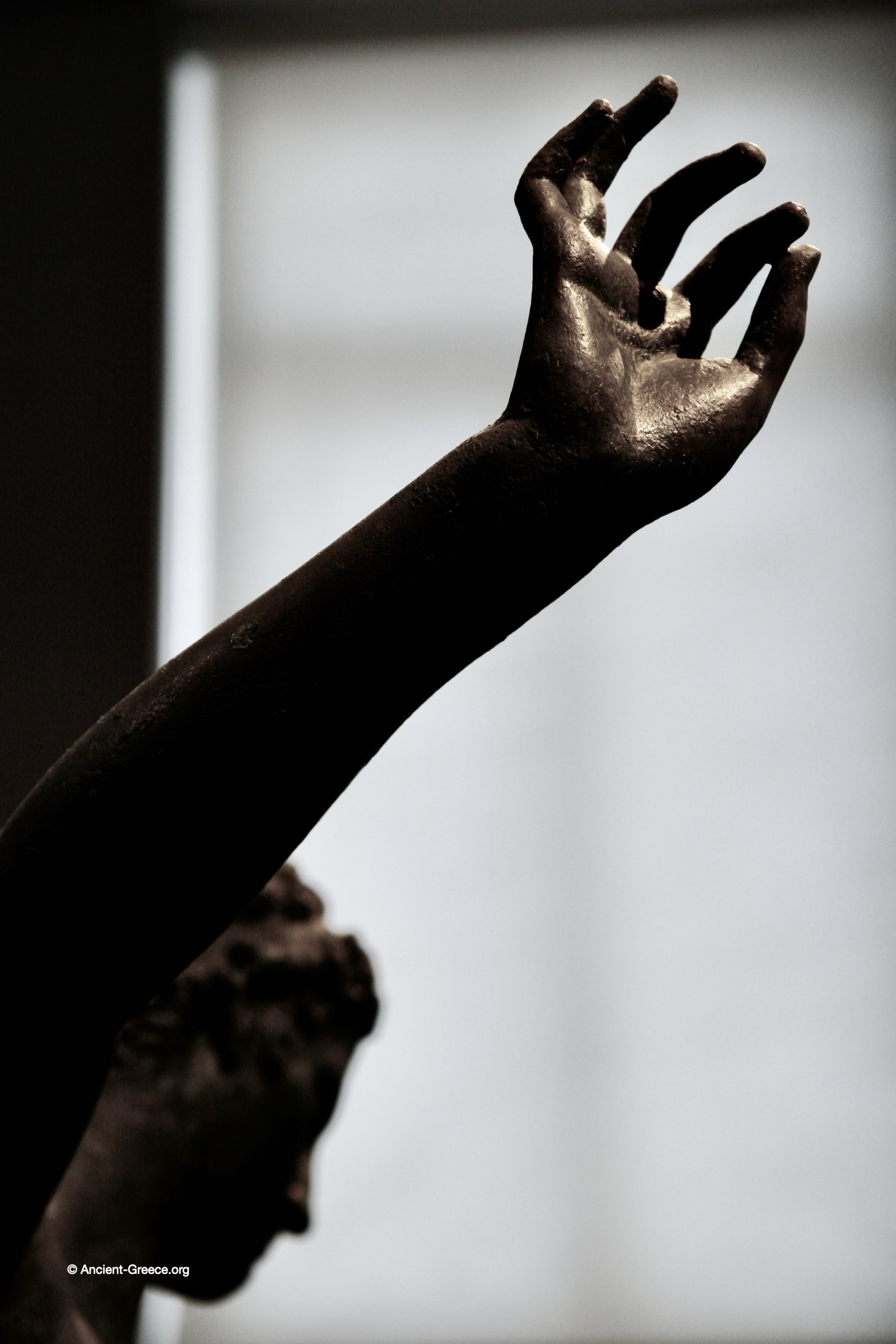 Ancient Greek art on exhibit in the National Archaeological Museum in Athens, Greece. Bronze statue of a youth studying an object. Marathon Youth. Detail. Bronze statue