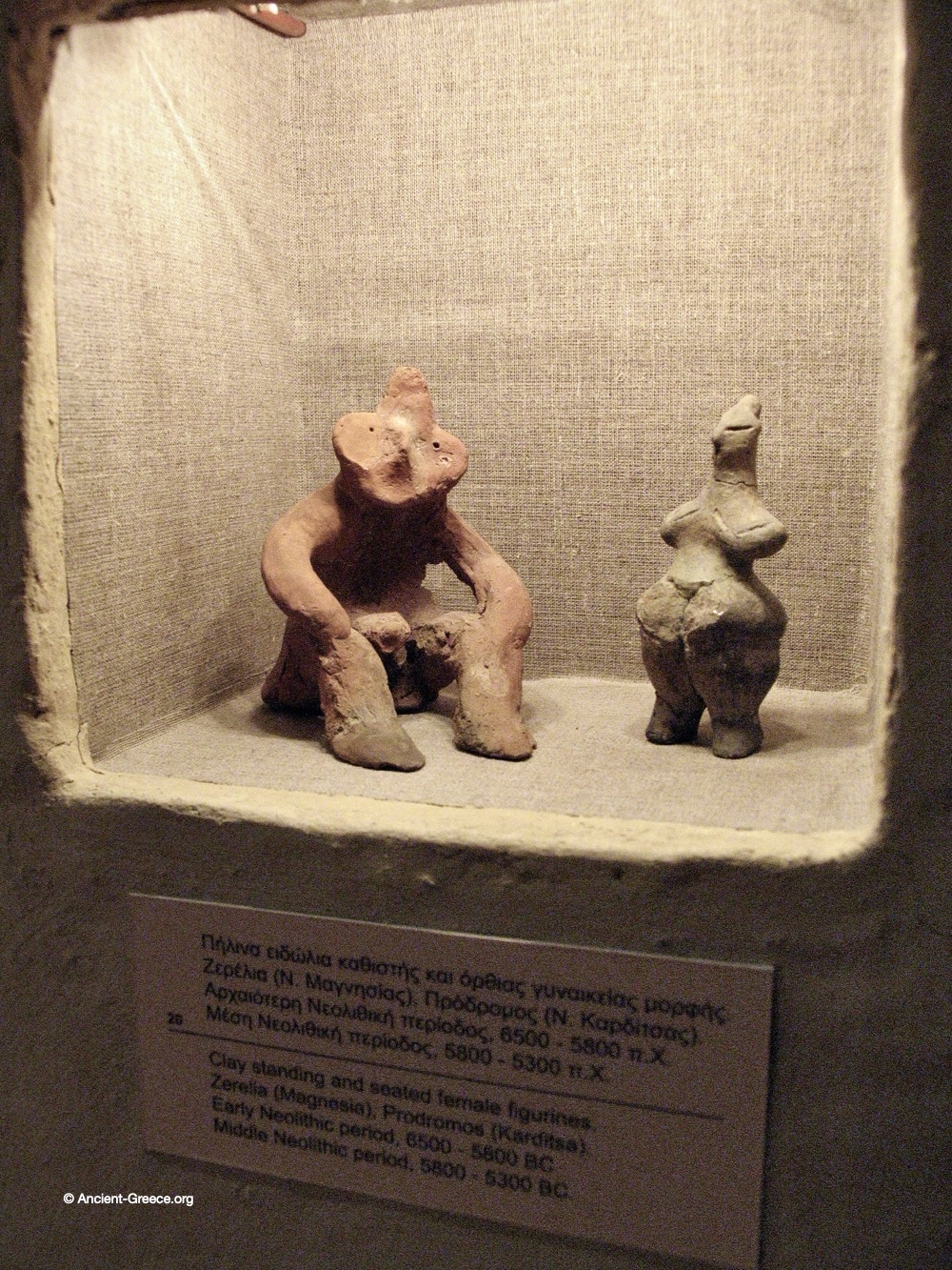 Clay standing and seated female figurines.