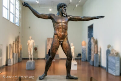 Bronze statue of Zeus with arms spread in a throwing motion