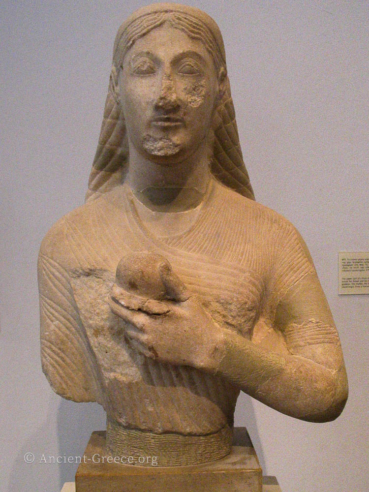 Upper body of marble statue of a kore holding an apple